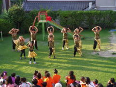 芝生広場で踊るダンスチームの子どもたち